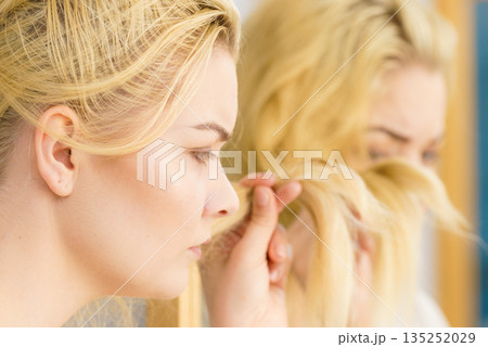 Woman having blonde split ends hair 135252029