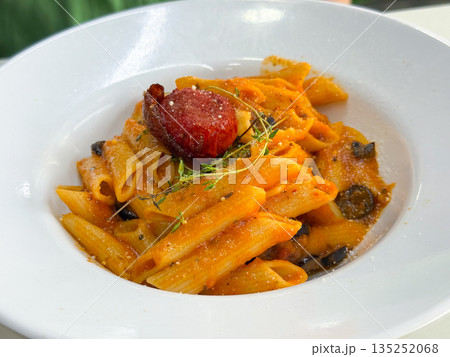 Pasta penne with tomato sauce and garnish. Culinary tradition, Italian flavor, nutrition, and restaurant dining as a representation of cultural taste and gourmet experience. 135252068