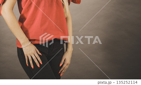Woman wearing red top and black jeans 135252114