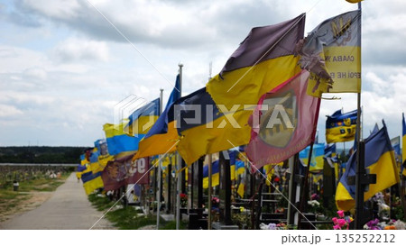 View on blue-yellow flags at countless graves of ukrainian soldiers alley of glory in Kharkiv. This site commemorates heroes and maintains the memory of wartime events in Ukraine. Slow moiton View on blue-yellow flags at countless graves of ukrainian soldiers alley of glory in Kharkiv. This site commemorates heroes and maintains the memory of wartime events in Ukraine. Slow moiton 135252212