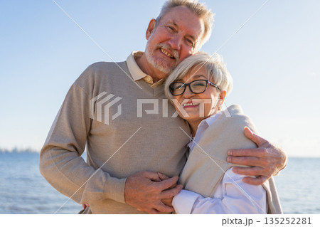 Senior mature couple hugging enjoying outdoor recreation walking on beach. Old husband wife embracing with tenderness love enjoying sweet bonding. Grandmother grandfather together. Family moment love Senior mature couple hugging enjoying outdoor recreation walking on beach. Old husband wife embracing with tenderness love enjoying sweet bonding. Grandmother grandfather together. Family moment love 135252281