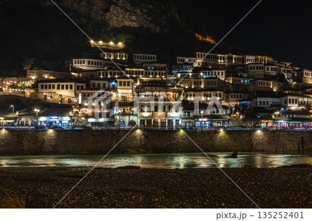 Night view of historic Albanian town with traditional Ottoman houses on a hillside with white stone architecture illuminated by street lights and Osum river flow, Berat, Albania 135252401