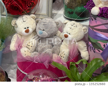 Three teddy bears inside a pink gift box with ribbons. Childhood, affection, nostalgia, and emotional comfort through soft toy collection Three teddy bears inside a pink gift box with ribbons. Childhood, affection, nostalgia, and emotional comfort through soft toy collection 135252660