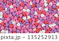 Background of colorful heart shaped sugar candies. Pink purple and red sweet confectionery texture for Valentine's Day. Top view of romantic love symbol pattern 135252913