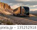 A futuristic black electric semi-truck driving on a desert highway. Modern transportation and sustainable logistics concept in a scenic mountain landscape at sunset 135252918