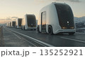 Convoy of futuristic autonomous electric trucks driving on a highway. Self-driving vehicles in a platoon representing the future of logistics and transportation technology 135252921