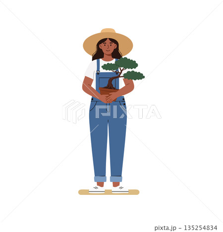 Woman gardener holding bonsai tree in blue overalls and straw hat standing isolated vector illustration Woman gardener holding bonsai tree in blue overalls and straw hat standing isolated vector illustration 135254834