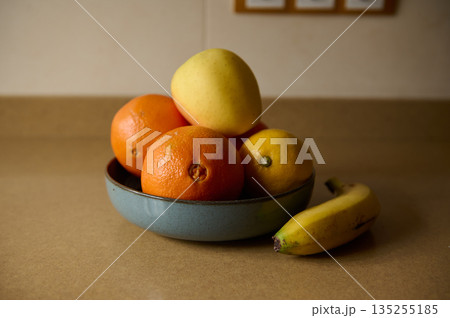 Fruit Bowl With Apples, Oranges, Bananas, and Lemons on a Kitchen Counter 135255185
