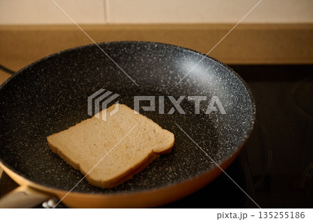 Slice Of Bread In A Nonstick Pan On A Warm Kitchen Stove 135255186
