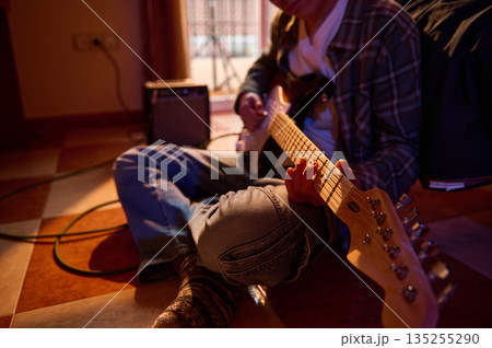 Casual Guitarist Plays Electric Guitar On Floor At Home With Amplifier Casual Guitarist Plays Electric Guitar On Floor At Home With Amplifier 135255290