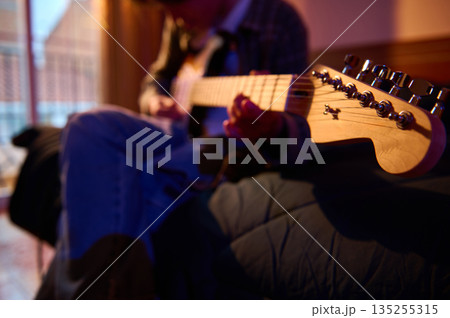 Guitar Player Strumming Electric Guitar Close-Up With Focus on Headstock and Knobs 135255315
