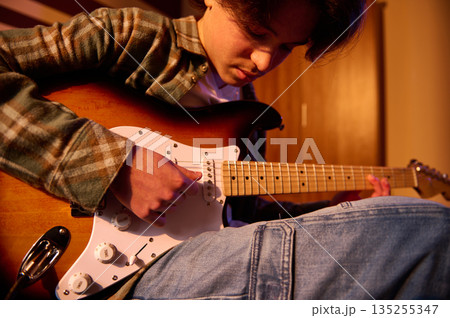 Young Man Playing Electric Guitar In Casual Flannel Shirt And Jeans, Close-Up 135255347