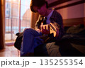 Cozy Room Guitarist Relaxing on Bed With Soft Lighting and Warm Evening Mood 135255354