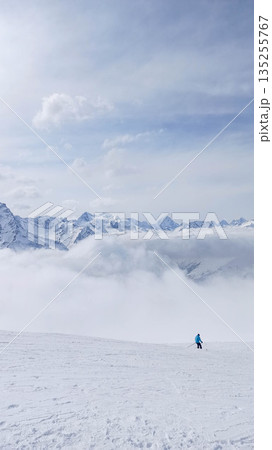 Lone skier on a wide snowy plateau Lone skier on a wide snowy plateau 135255767