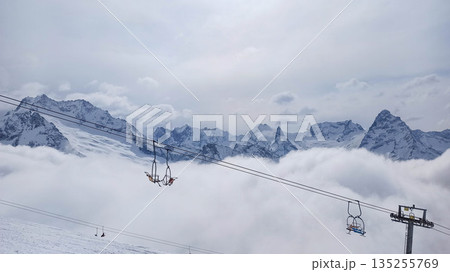 Chairlift above clouds at Dombay ski resort Chairlift above clouds at Dombay ski resort 135255769