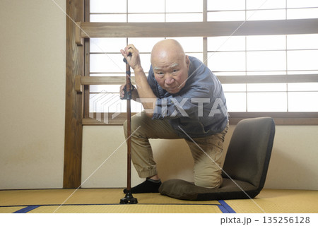 杖を使って室内でリハビリをする老人 杖を使って室内でリハビリをする老人 135256128