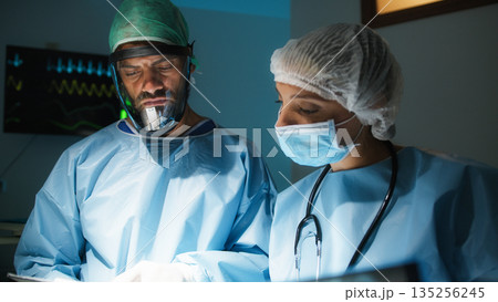 Medical team studies medical record 135256245