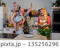Happy household enjoying lively celebration, Families rejoice together in cheerful kitchen setting, Lively and joyful family celebration captured spontaneously in kitchen 135256296