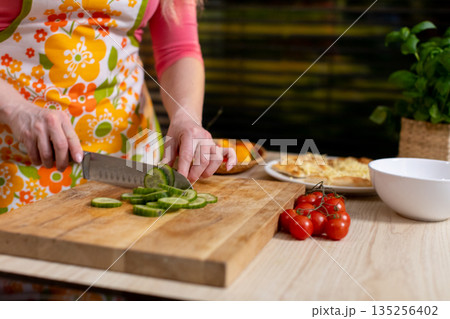 Aromatic herbs and ripe vegetables assembled in comfortable kitchen space, Creating vibrant and healthy salad with fresh ingredients in warm culinary environment 135256402