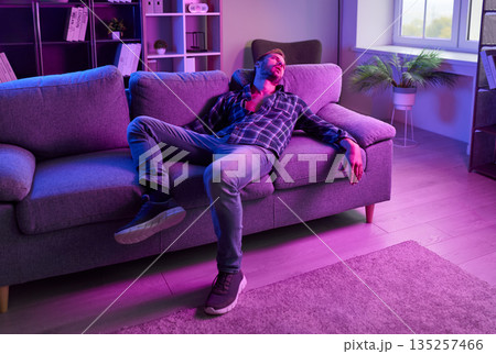 Man with drugs dependence and addiction lying on home sofa after nightclub party 135257466