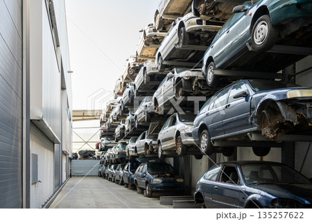 Stacked cars in scrapyard with multiple vehicles Stacked cars in scrapyard with multiple vehicles 135257622