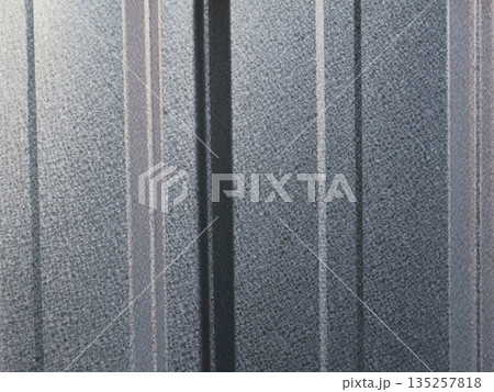 Textured metal siding panels reflecting natural light with copy space for industrial design mockups and abstract architectural background usage 135257818
