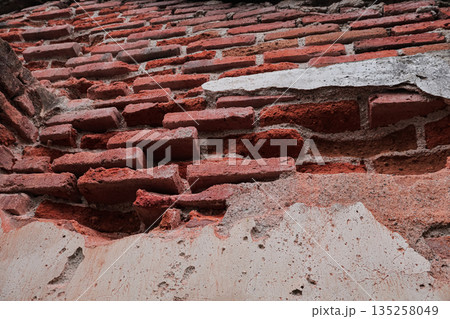 Weathered brick wall texture with crumbling plaster, creating a rustic and aged background for architectural detail and historical preservation 135258049