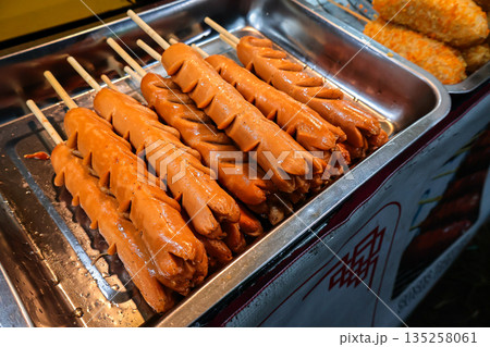 Grilled Sausage Skewers Displayed on Tray with Natural Light, Street Food Vendor Setting, Perfect for Culinary Promotion and Gourmet Food Concepts 135258061