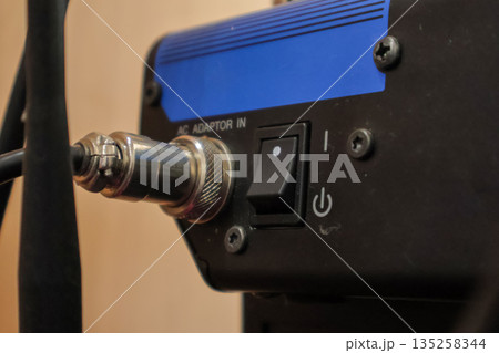 Connector and Switch on Black Device, close-up detailed view of power components and cable connections for industrial equipment use, copy space. 135258344