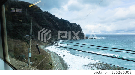 山陰本線の鈍行列車に乗って冬の日本海を眺めているイメージ風景 135260303