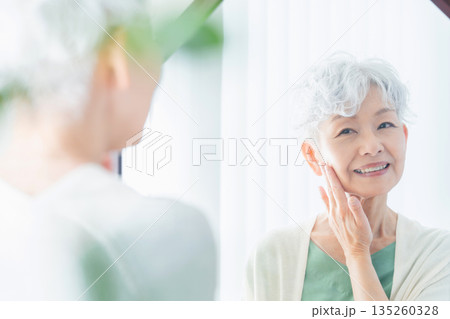 肌の潤いを実感するシニア女性 135260328