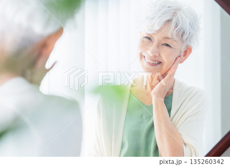肌の潤いを実感するシニア女性 肌の潤いを実感するシニア女性 135260342