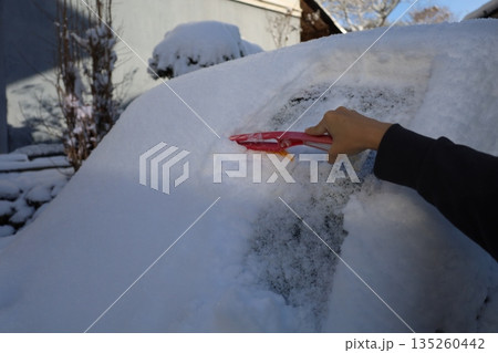 積雪した車の雪下ろし作業、冬の日常と安全対策 積雪した車の雪下ろし作業、冬の日常と安全対策 135260442