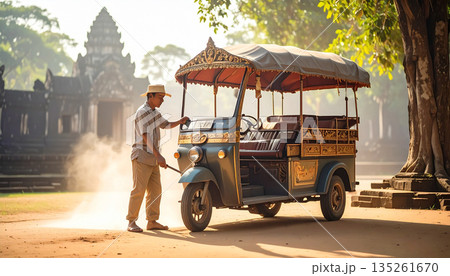 Traditional Cambodian Tuk-Tuk Driver with Vehicle at Angkor Wat Temple Ruins in Siem Reap at Sunset Traditional Cambodian Tuk-Tuk Driver with Vehicle at Angkor Wat Temple Ruins in Siem Reap at Sunset 135261670