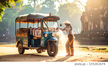 Female Tuk-Tuk Driver Wearing Conical Hat Standing by Her Vehicle Near Ancient Cambodian Temple Female Tuk-Tuk Driver Wearing Conical Hat Standing by Her Vehicle Near Ancient Cambodian Temple 135261674