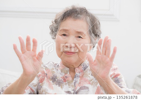 元気に両手でバイバイなど手を振る笑顔の高齢女性　健康やスッキリした気持ちのなどのイメージ	 135261878