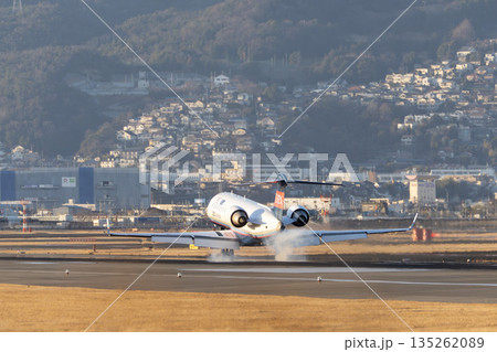 夕方の大阪空港（伊丹空港）　着陸中の飛行機　大阪府豊中市 135262089