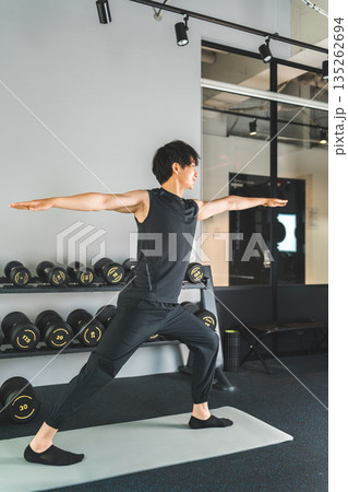 トレーニングジムでヨガ,ストレッチのエクササイズをする若いアジア人男性 トレーニングジムでヨガ,ストレッチのエクササイズをする若いアジア人男性 135262694