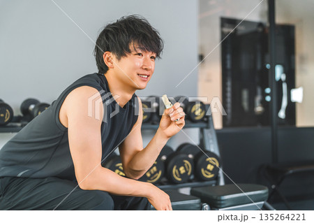 トレーニング前後に栄養補給する筋トレをする若いアジア人男性 トレーニング前後に栄養補給する筋トレをする若いアジア人男性 135264221