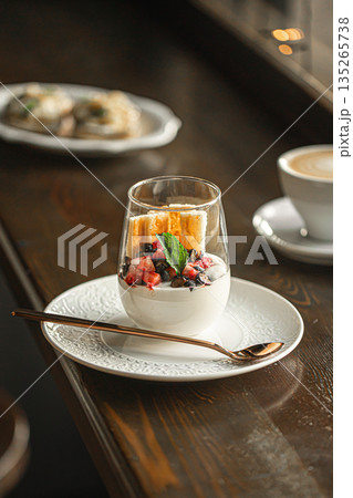 Creamy berry dessert in glass on cafe table Creamy berry dessert in glass on cafe table 135265738
