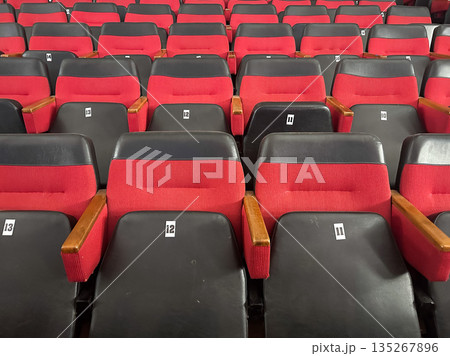 Empty red and black theater seats in an auditorium. Empty red and black theater seats in an auditorium. 135267896