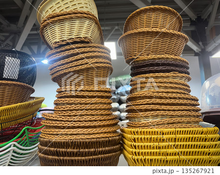 Stack of woven wicker baskets arranged in vibrant display. 135267921