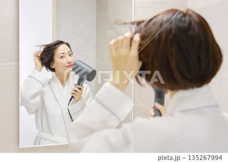 ドライヤーで髪を乾かす女性 135267994