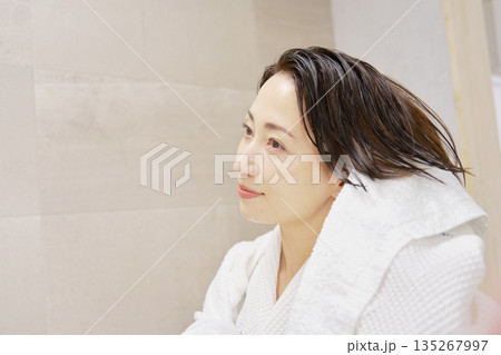 お風呂上がりに濡れている髪をバスタオルで拭く女性　 135267997