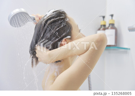 シャワーで髪を洗い流す女性 シャワーで髪を洗い流す女性 135268005