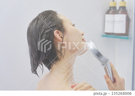 シャワーで体を洗い流す女性 135268006