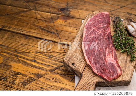 Raw rump cap steak, uncooked beef meat, showcasing its rich marbling and vibrant color. wooden background. top view Raw rump cap steak, uncooked beef meat, showcasing its rich marbling and vibrant color. wooden background. top view 135269879