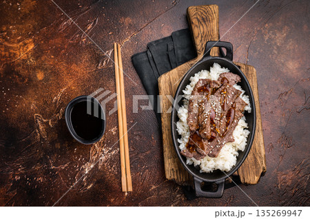 Exquisite Japanese BBQ, highlighting beautifully charred meats and rice. Perfectly seasoned, this dish promises a rich and savory flavor in every bite. brown background. top view 135269947