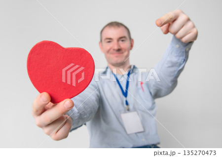 Smiling cardiologist doctor holding a healthy heart in his hands Smiling cardiologist doctor holding a healthy heart in his hands 135270473