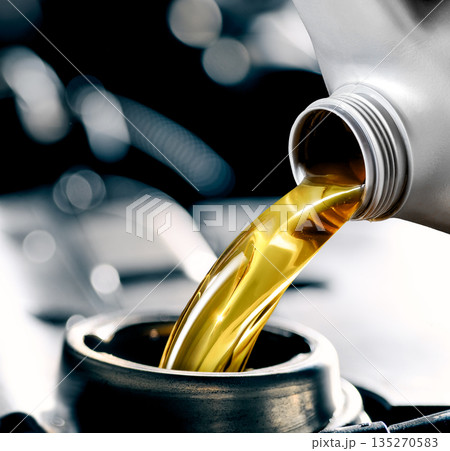 Pouring motor oil into the car engine Pouring motor oil into the car engine 135270583